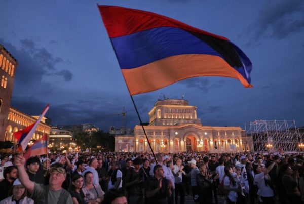 Una manifestazione nel centro di Erevan, con in primo piano una bandiera armena che sventola